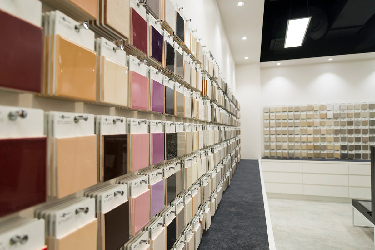 Beaumont Tiles showroom wall featuring a wide selection of coloured and neutral tile samples, helping customers compare finishes, colours and design styles for renovation projects.