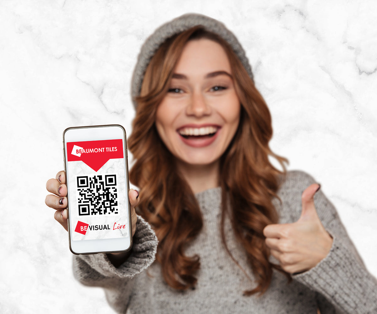 Person holding a smartphone displaying the Beaumont Tiles BeVisual Live QR code, providing quick access to the room visualiser tool for previewing tiles and flooring in your space.
