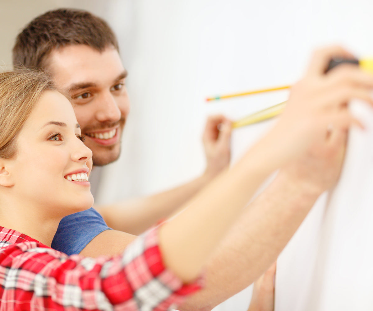 Two people measuring with a tape measure