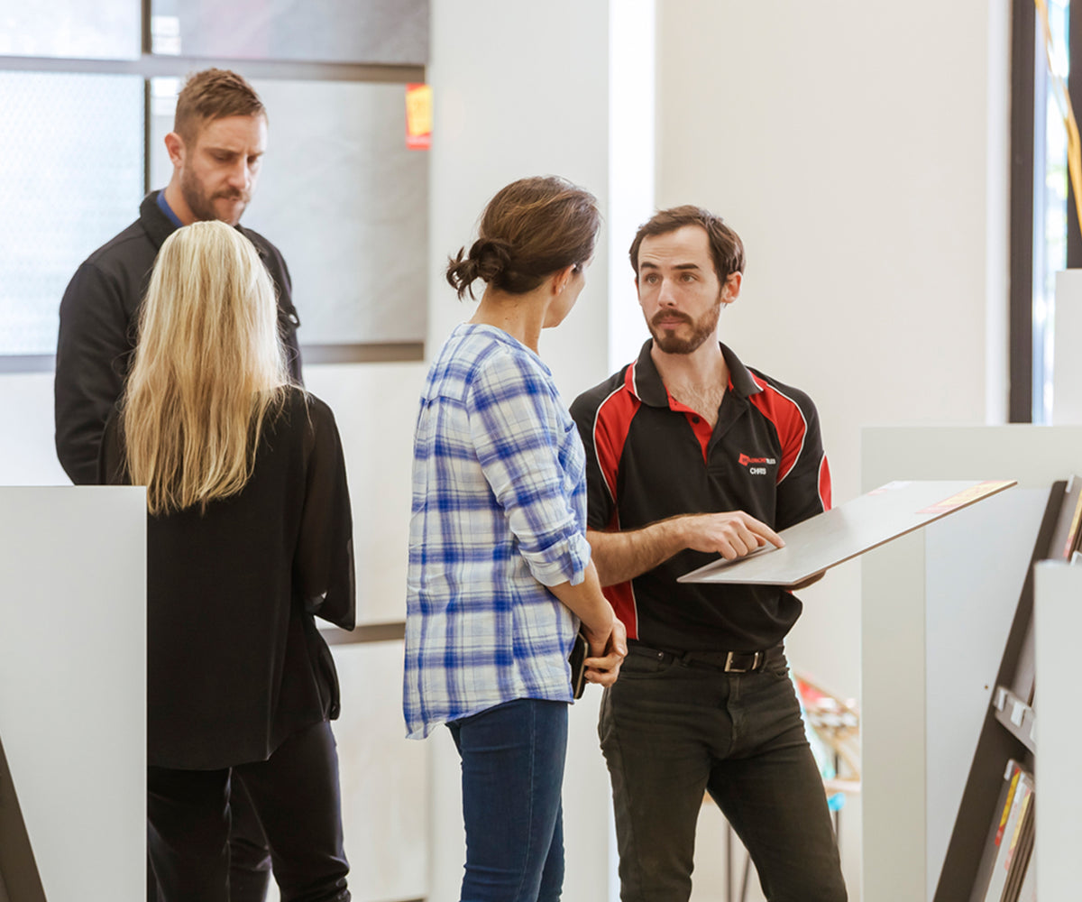 Beaumont Tiles showroom consultant helping customers compare large-format tile samples and design options during a personalised in-store consultation.