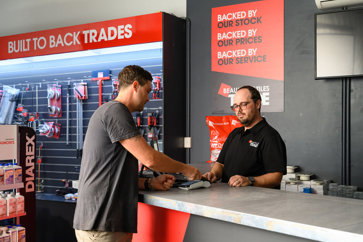 Trade customer making a purchase at the Beaumont Tiles Trade counter, receiving service and support for tiling materials, tools and installation products.