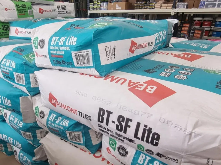 Stacked bags of Beaumont Tiles BT-SF Lite lightweight tile adhesive stored in a trade warehouse, ready for professional wall and floor tile installations.