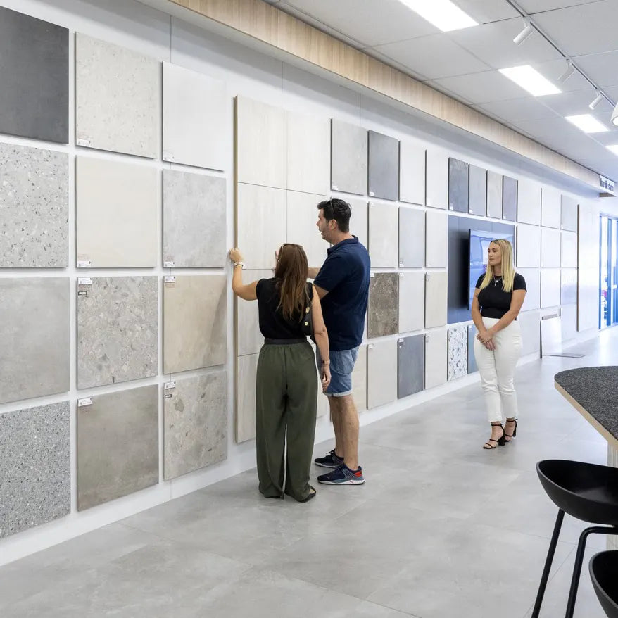 Beaumont Tiles showroom featuring customers comparing large-format wall and floor tile samples with expert design advice.