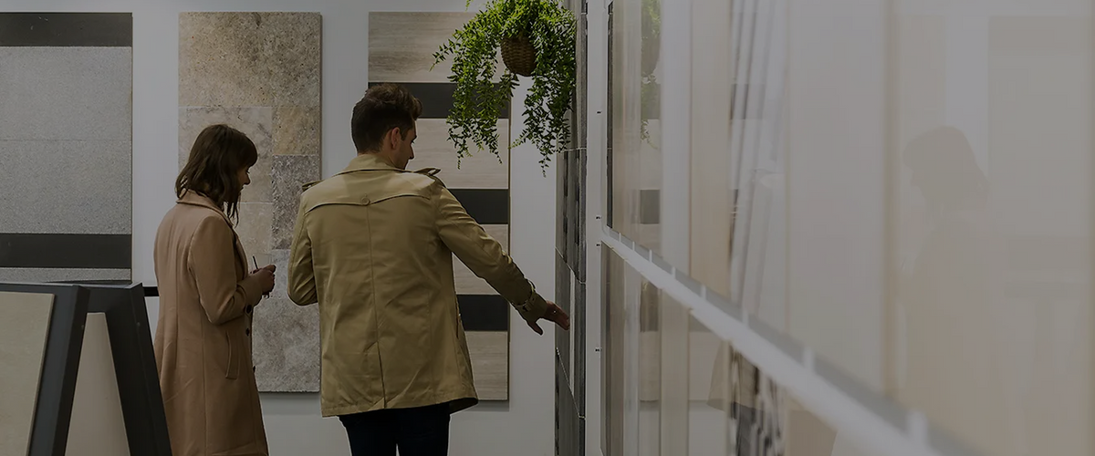 Customer browsing large-format tile displays in a Beaumont Tiles showroom, comparing wall and floor tile options for a home renovation project.